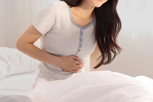 잠자리에서 복부 불편을 느끼는 모습