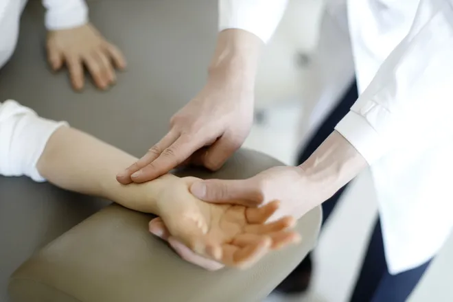 손목에서 맥을 짚어 상태를 확인하는 모습